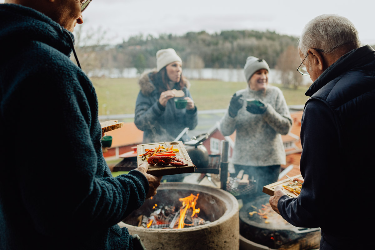 Konferensgäster som lagar mat över öppen eld på Bauergårdens grillplats med utsikt över Bunn