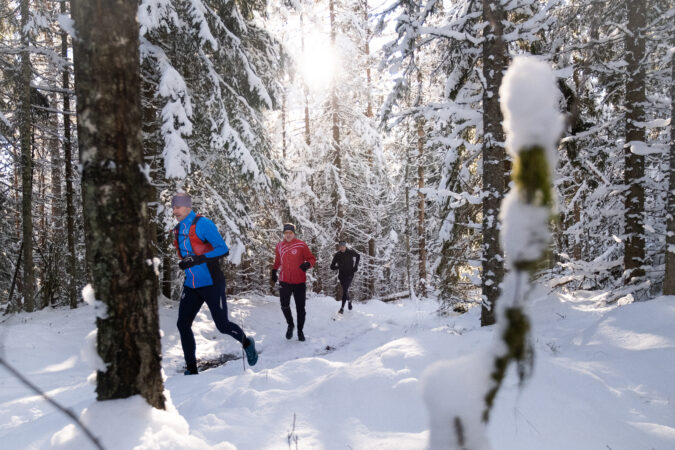 Löpare på en snöig stig i Bauers trolska natur vid Bauergården i Bunn