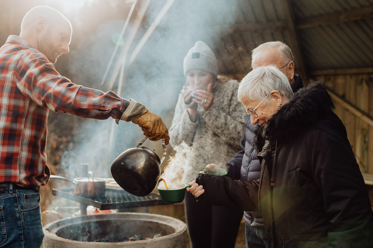 Konferensgaster som dricker kokkaffe under vindskyddet på Bauergårdens grillplats